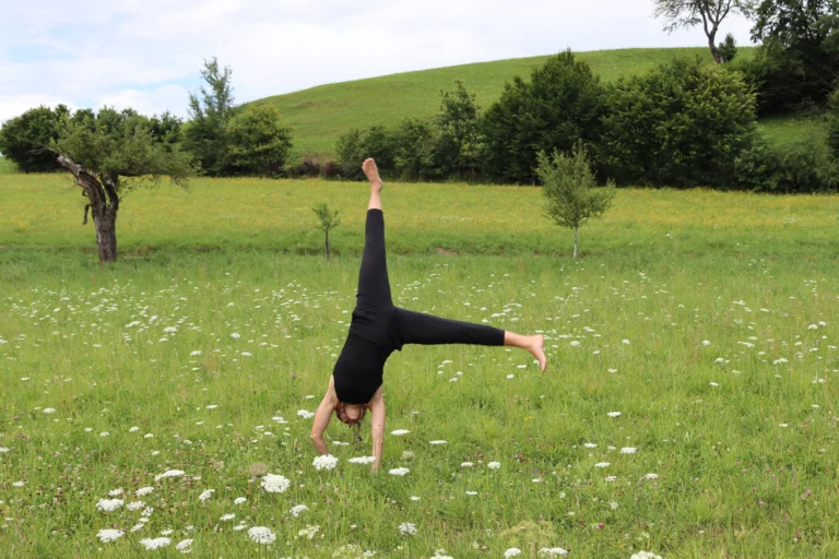Stefanie Jahn schlägt ein Rad in der Wiese