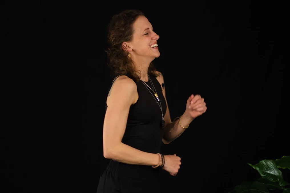 Stefanie Jahn tanzend und lachend vor schwarzem Hintergrund